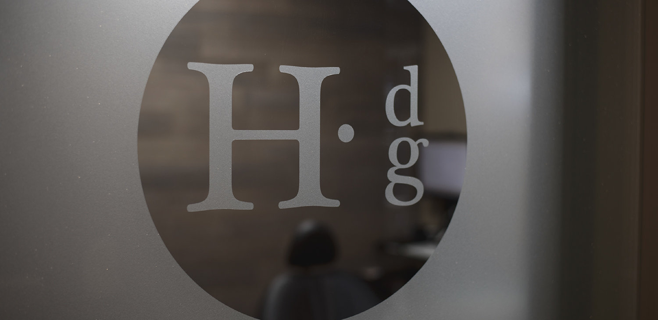 Holger Dental Group logo on a glass door