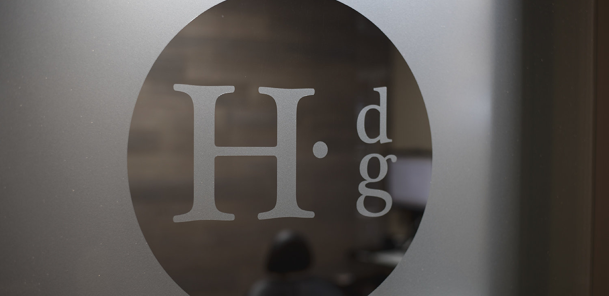 The Holger Dental Group logo on a glass door