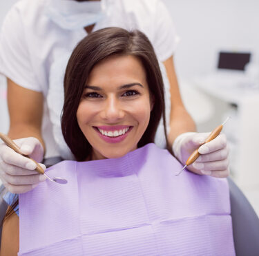 Woman smiling while root canal procedure in Minneapolis